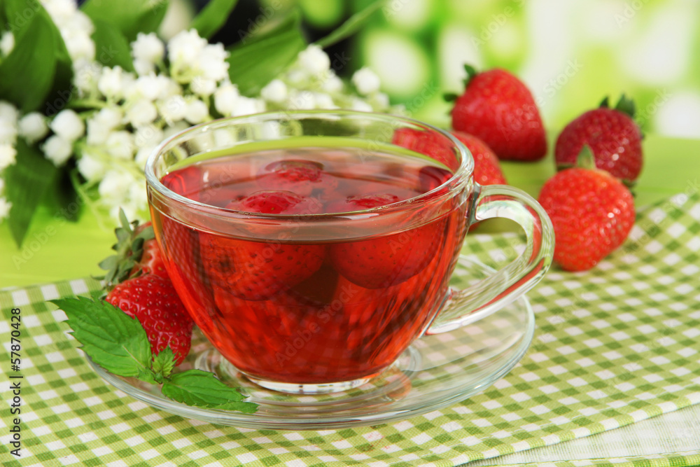 Delicious strawberry tea on table on bright background Delicious strawberry tea on table on bright background