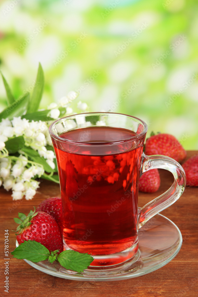 Delicious strawberry tea on table on bright background Delicious strawberry tea on table on bright background