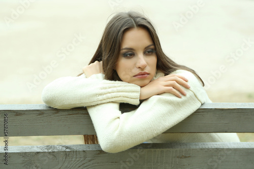 Canvastavla Young lonely woman on bench in park