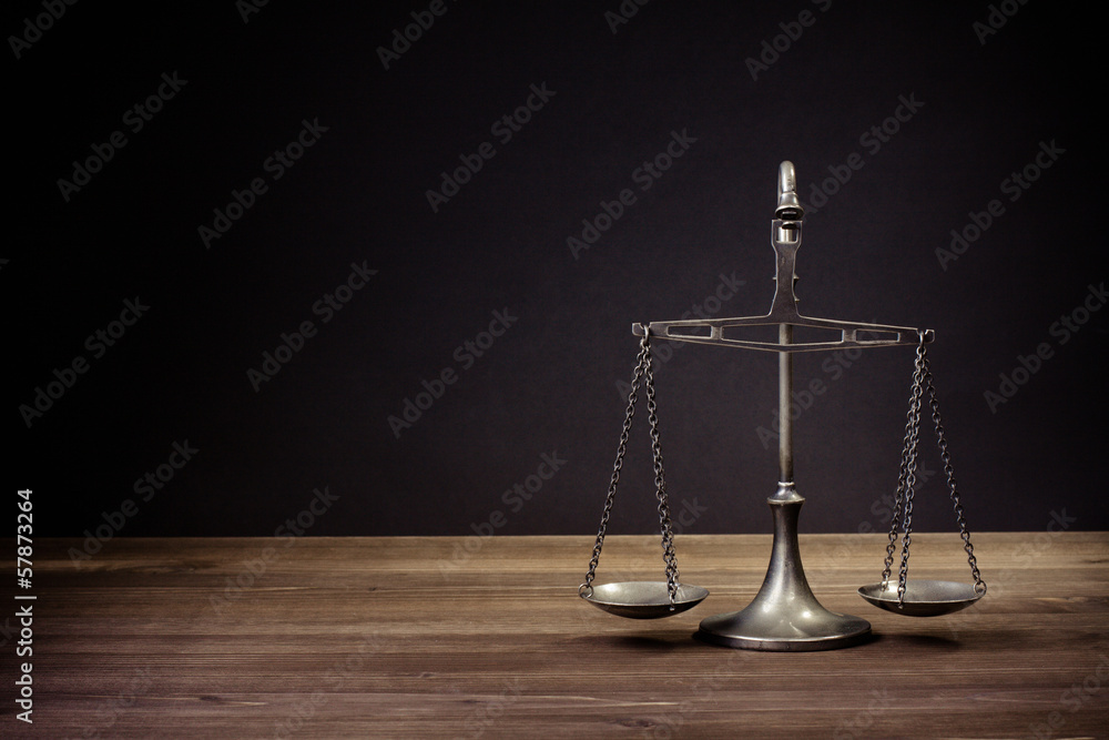 Law scales on table in front black background. Symbol of justice Law scales on table in front black background. Symbol of justice