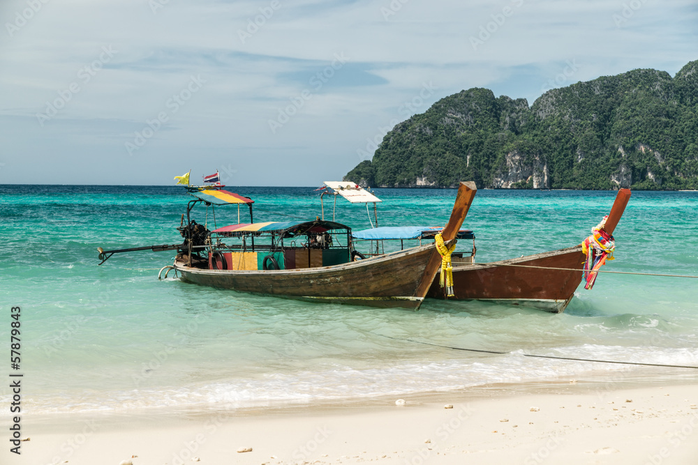 thai longtail boats anchored in the surf on ko phi phi thailand