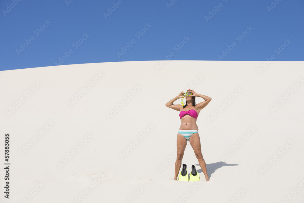 Active retired woman on beach sand dune