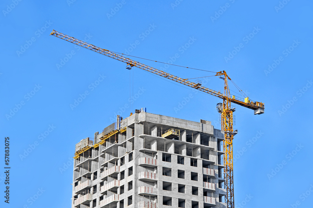 Crane and building construction site against blue sky Crane and building construction site against blue sky