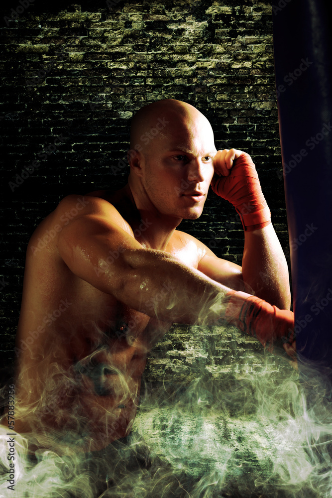 Fototapeta premium boxer man during boxing hiting heavy bag at training fitness