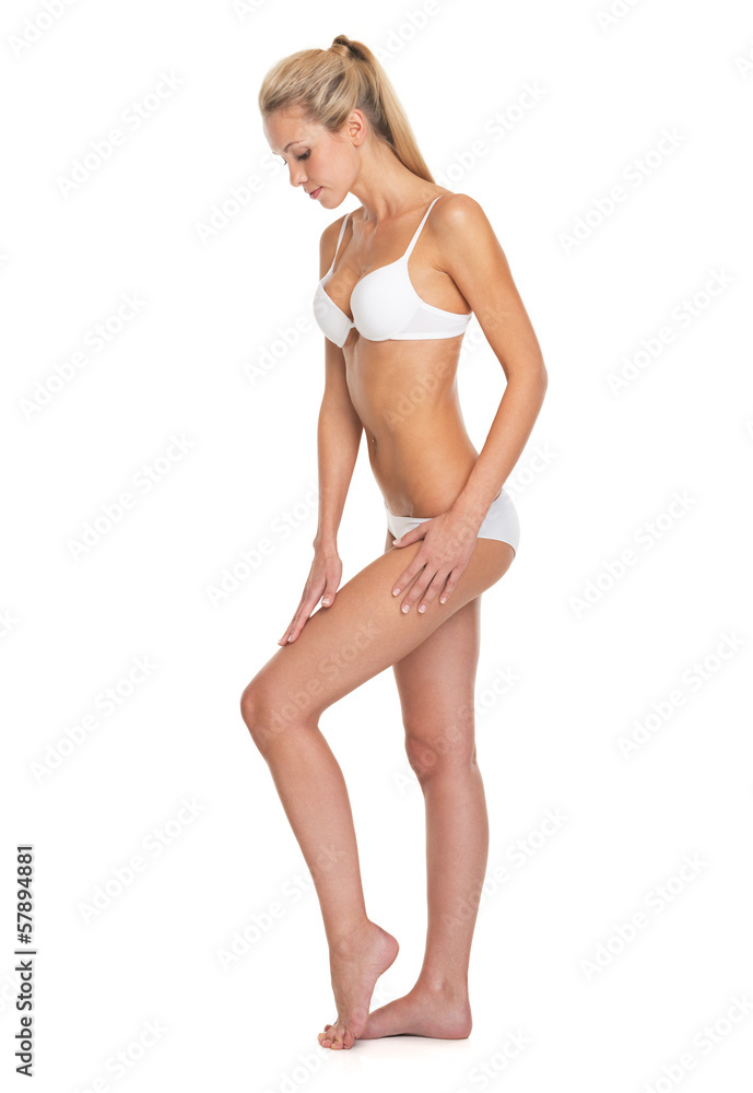 Full length portrait of young woman in lingerie touching leg Full length portrait of young woman in lingerie touching leg