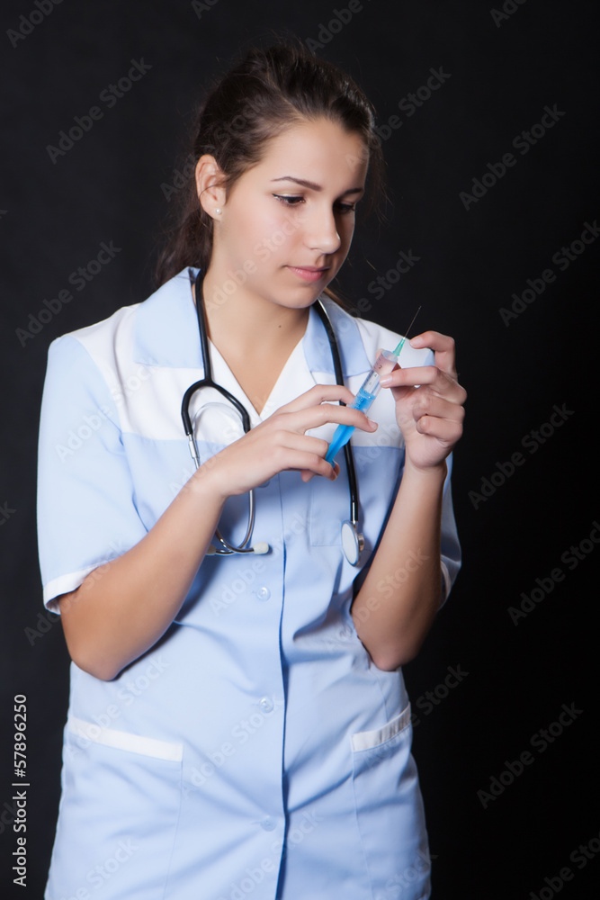 Young female doctor with stethoscope and syringe Young female doctor with stethoscope and syringe