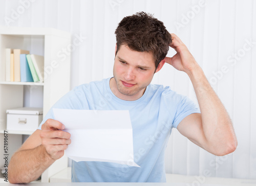 Confused Man Looking At Paper