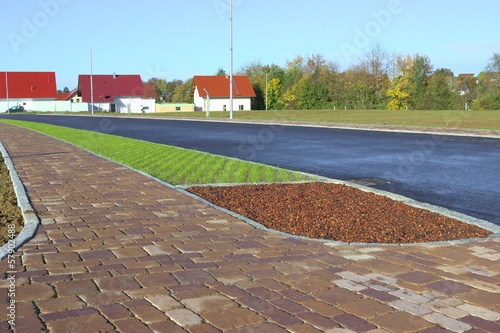 Neues Betonpflaster auf Parkstreifen und Gehweg mit Bauminsel photo