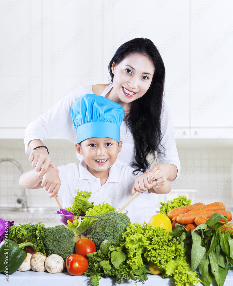 Attractive mother and son preparing a salad Attractive mother and son preparing a salad