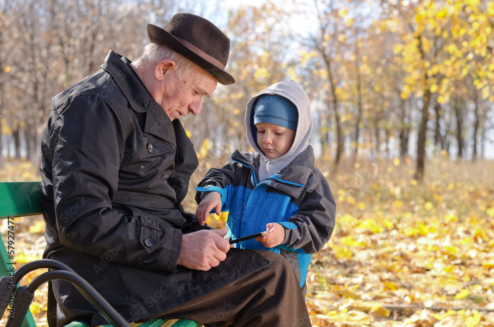 Elderly man with his grandson in the park