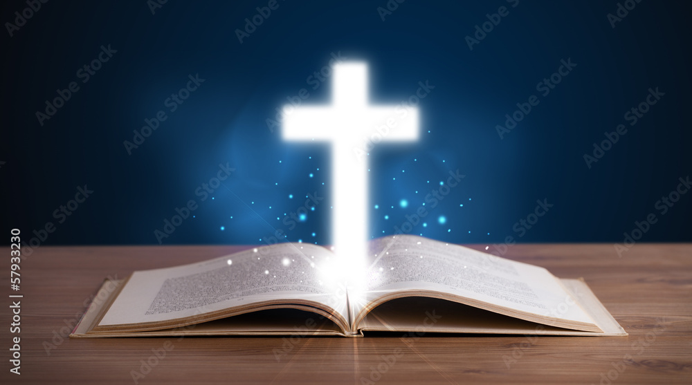Open holy bible with glowing cross in the middle Open holy bible with glowing cross in the middle