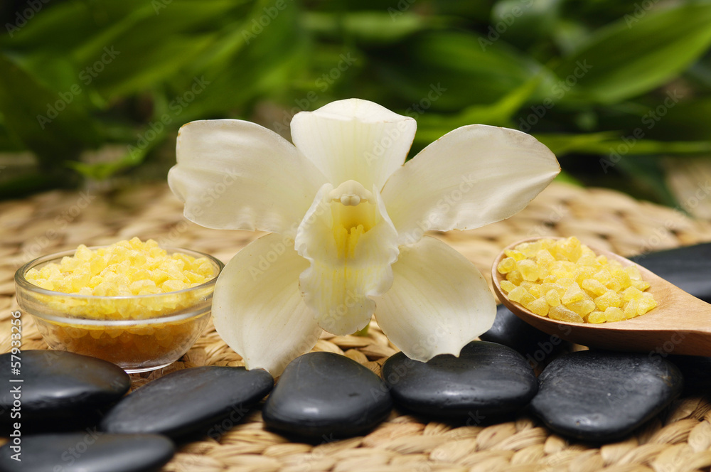 SPA background. Salt in bowl and stones with orchid on mat SPA background. Salt in bowl and stones with orchid on mat