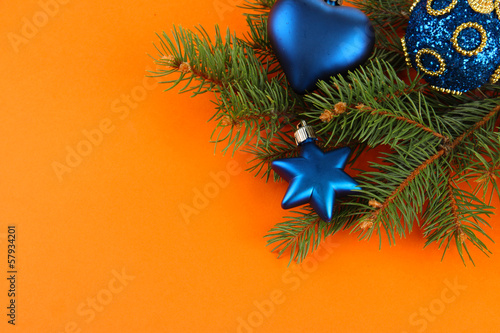 Beautiful Christmas decorations on fir tree on orange