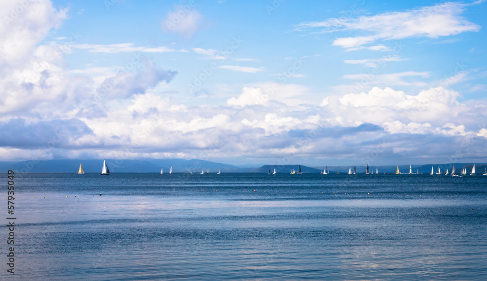 Seascape with sailboats the background of the blue sky.
