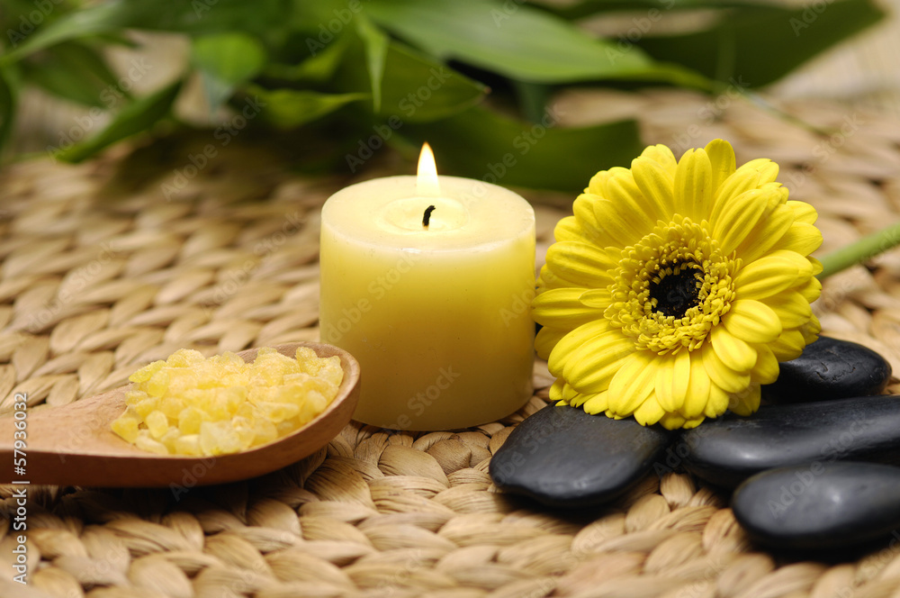 candle and daisies flower and bamboo leaf on wicker mat