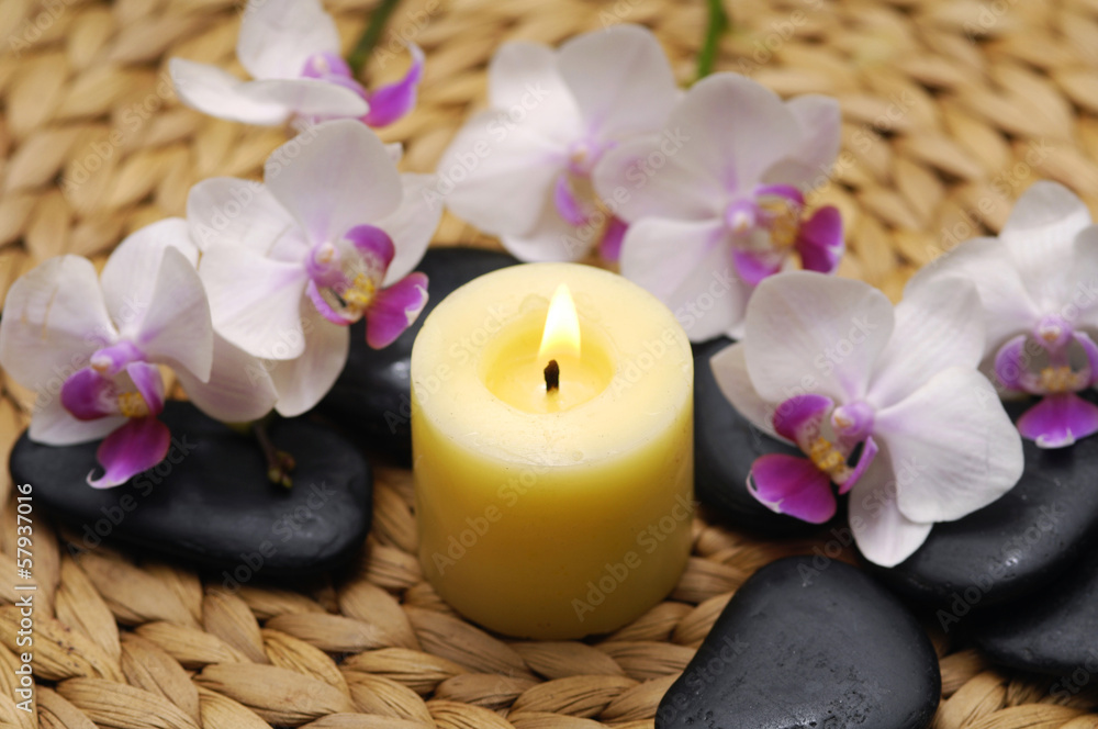 Yellow Candle and stones with orchid with stones on mat Yellow Candle and stones with orchid with stones on mat