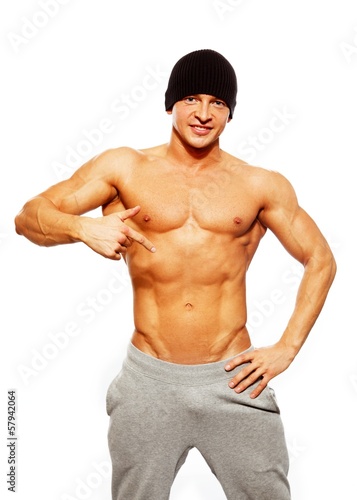 Handsome man with muscular torso in beanie hat posing © Nejron Photo