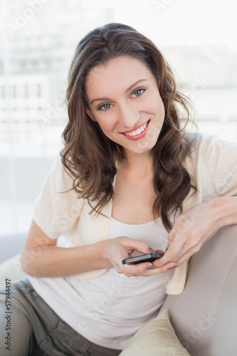 Portrait of relaxed young woman text messaging on sofa Free Download Portrait of relaxed young woman text messaging on sofa - GFXLoad