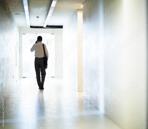 Businessman walking down the corridor on the phone