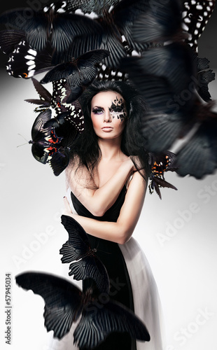 Woman with black hair and art make up and butterflies