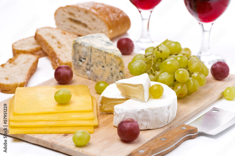 Cheese platter, grapes, bread and red wine on board Cheese platter, grapes, bread and red wine on board