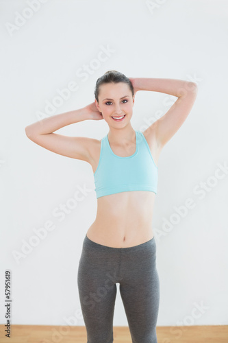 Smiling fit woman standing in fitness studio © lightwavemedia
