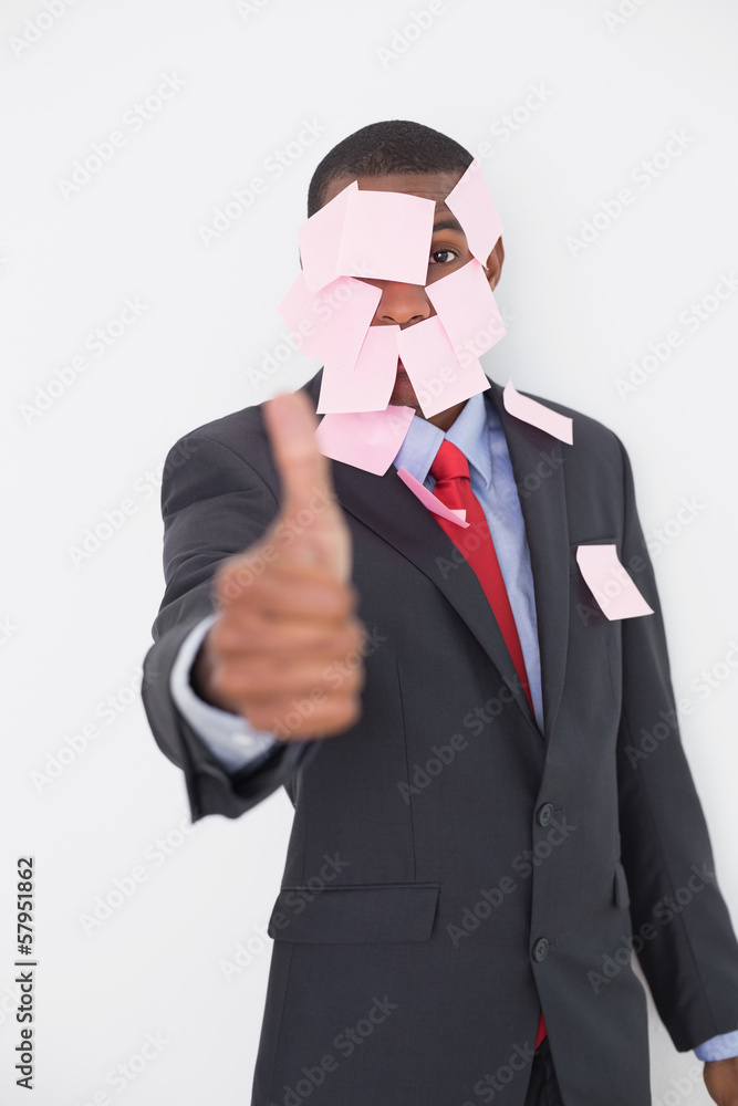 Afro businessman covered in blank notes gesturing thumbs up Afro businessman covered in blank notes gesturing thumbs up