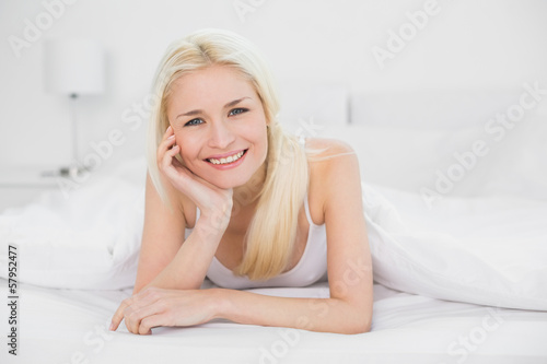 Portrait of a beautiful smiling young blond in bed