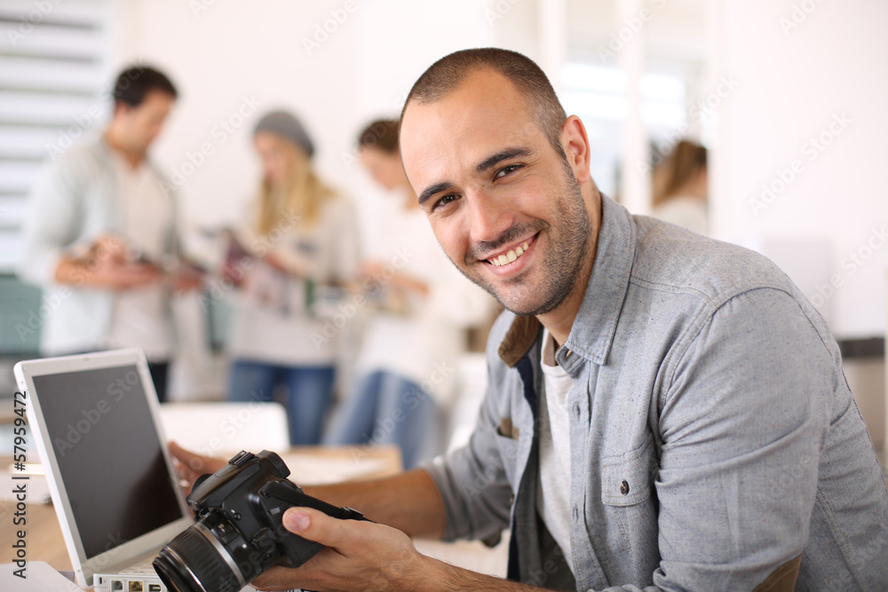 CHeerful reporter working in office on laptop CHeerful reporter working in office on laptop