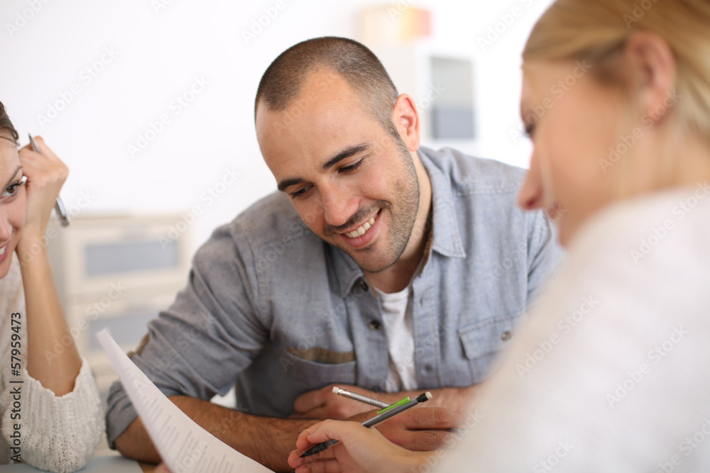Man reading contract commented by business partner Man reading contract commented by business partner