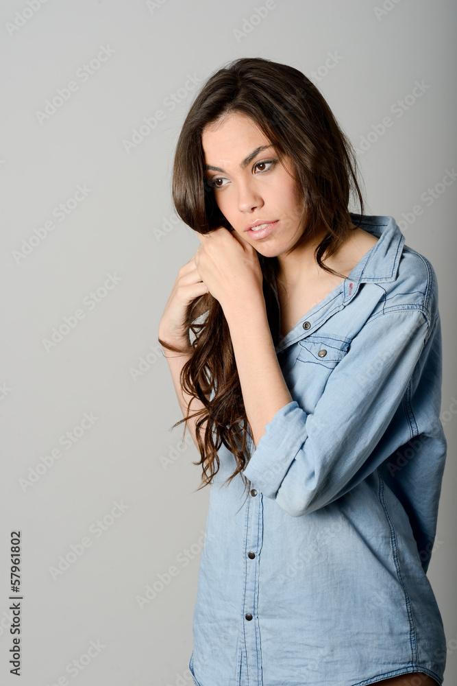 Young casual woman style over gray background. Studio portrait Young casual woman style over gray background. Studio portrait