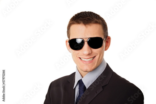 Portrait of young smiling businessman in sunglasses.