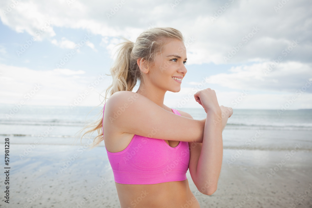 Smiling toned woman exercising on beach Smiling toned woman exercising on beach