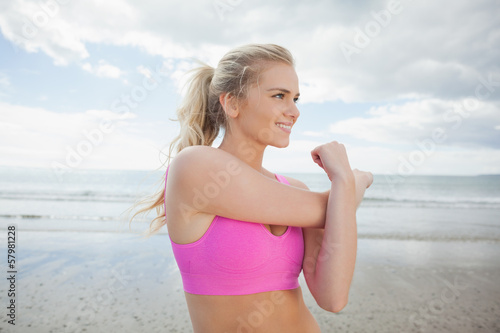 Smiling toned woman exercising on beach © WavebreakMediaMicro