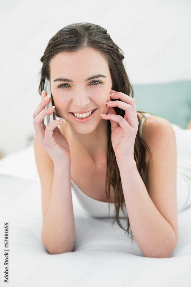 Relaxed young woman using mobile phone in bed Relaxed young woman using mobile phone in bed