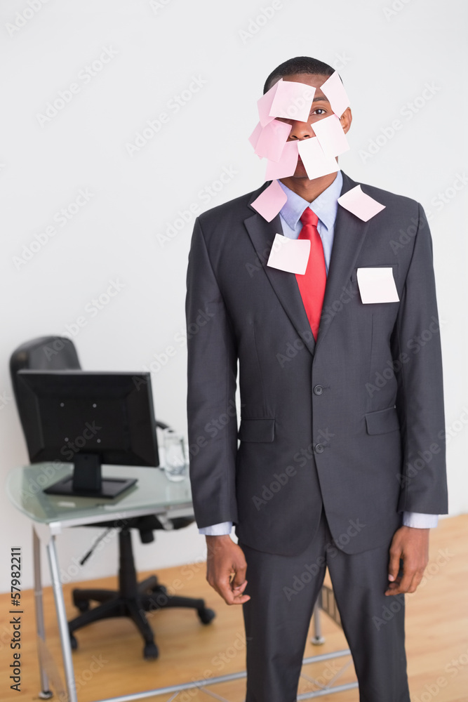 Businessman covered in blank notes at office Businessman covered in blank notes at office