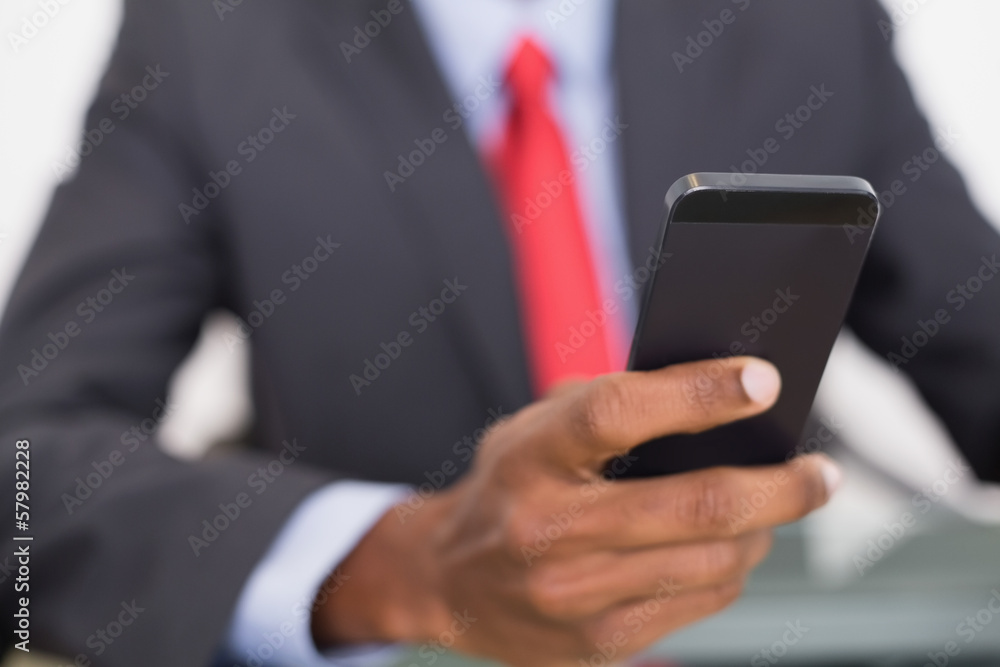 Mid section of well dressed businessman text messaging Mid section of well dressed businessman text messaging