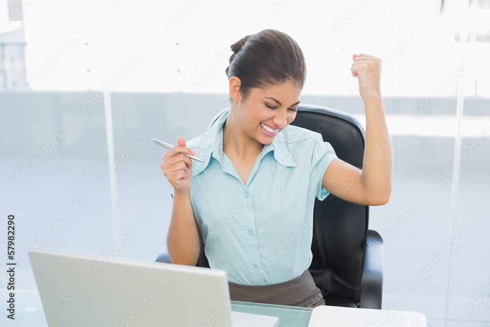 Happy businesswoman in front of laptop in office Happy businesswoman in front of laptop in office