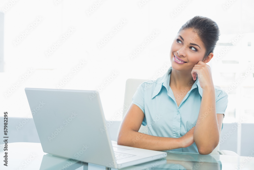 Thoughtful businesswoman in front of laptop in office Thoughtful businesswoman in front of laptop in office