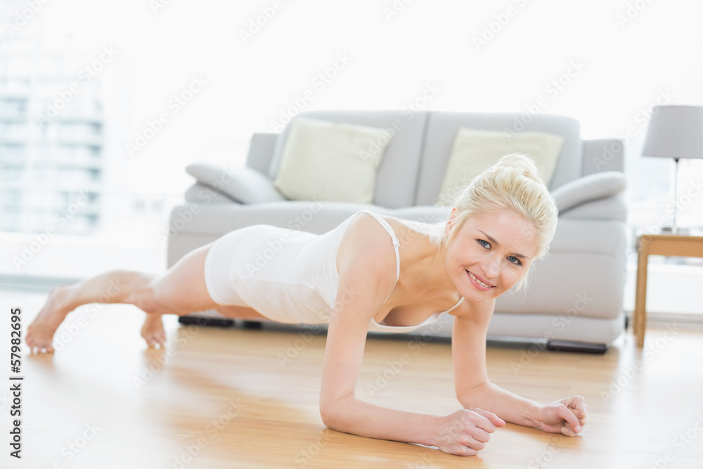 Sporty woman doing push ups in fitness studio Sporty woman doing push ups in fitness studio