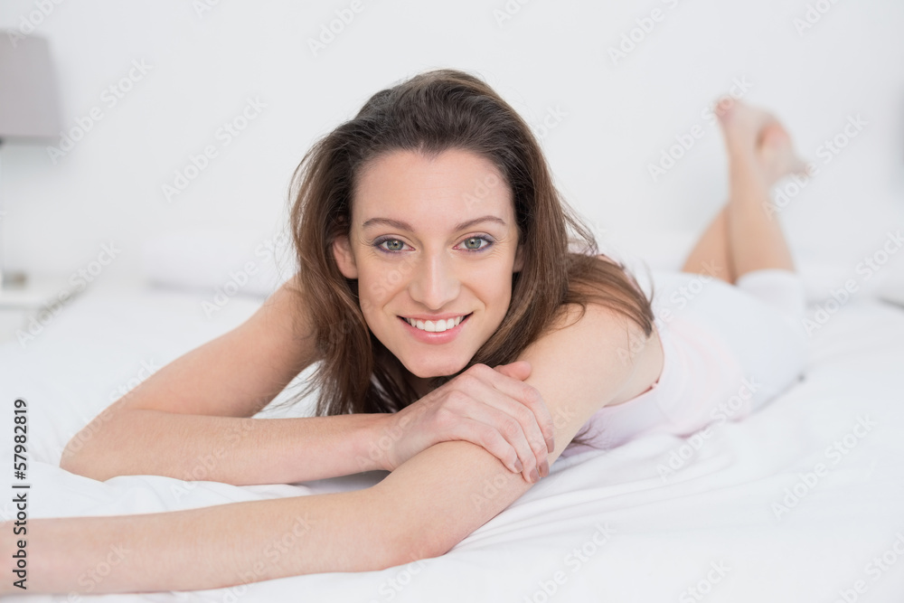 Full length portrait of smiling woman resting in bed Full length portrait of smiling woman resting in bed