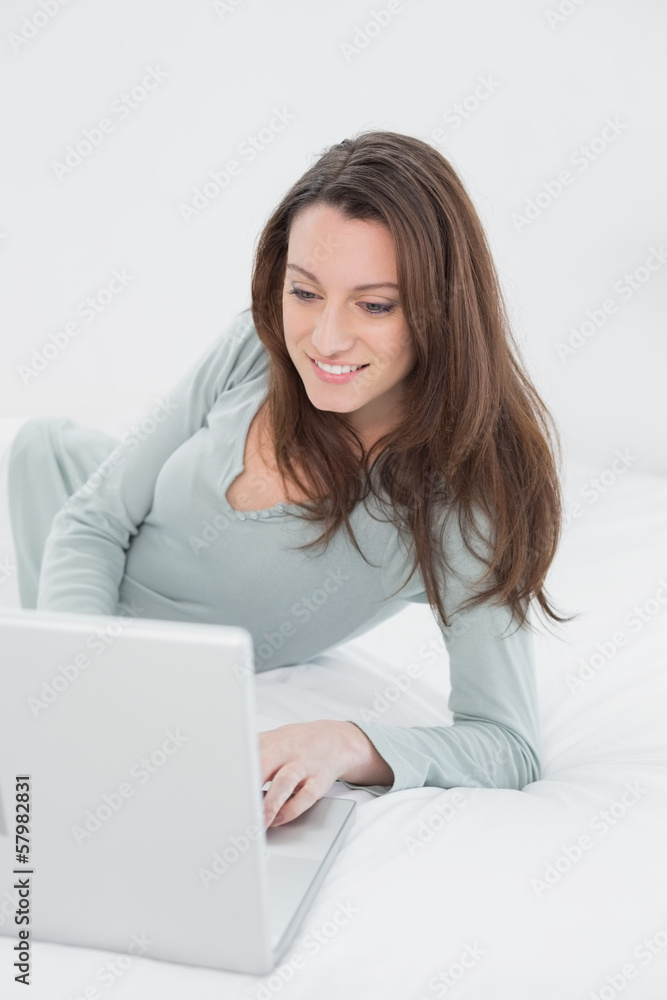 Happy relaxed casual woman using laptop in bed Happy relaxed casual woman using laptop in bed