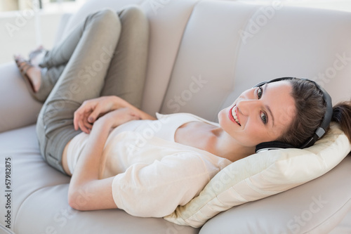 Relaxed casual young woman enjoying music on sofa