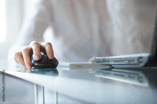Businesswoman clicking on cordless mouse