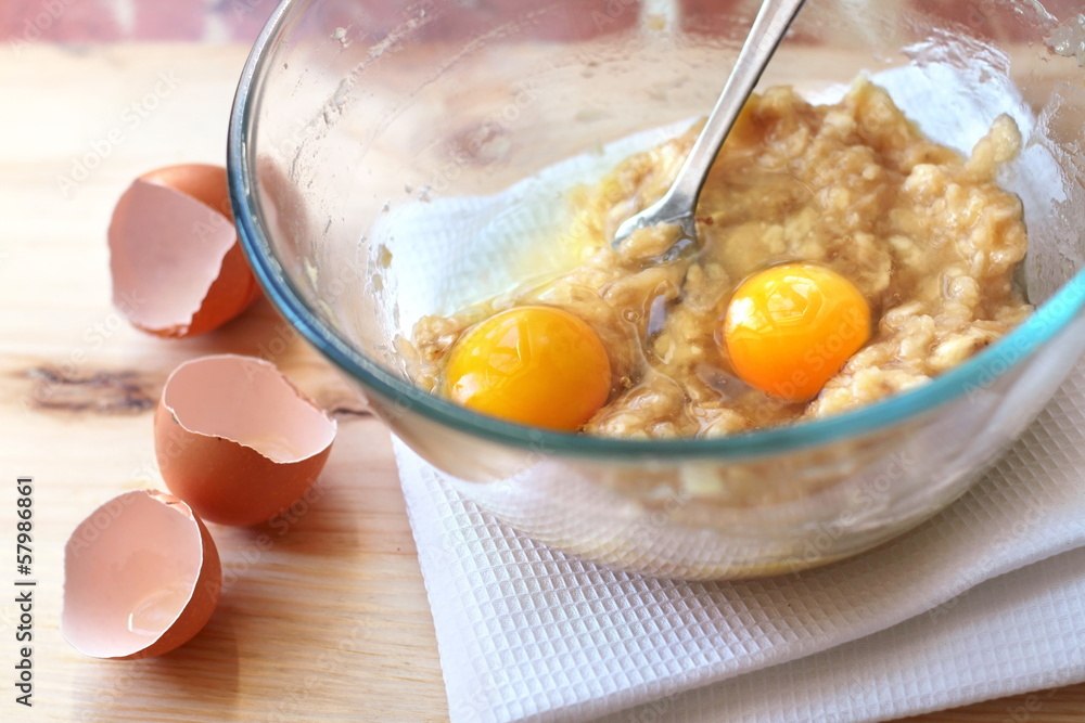 Mix of banana and eggs in a glass bowl Mix of banana and eggs in a glass bowl