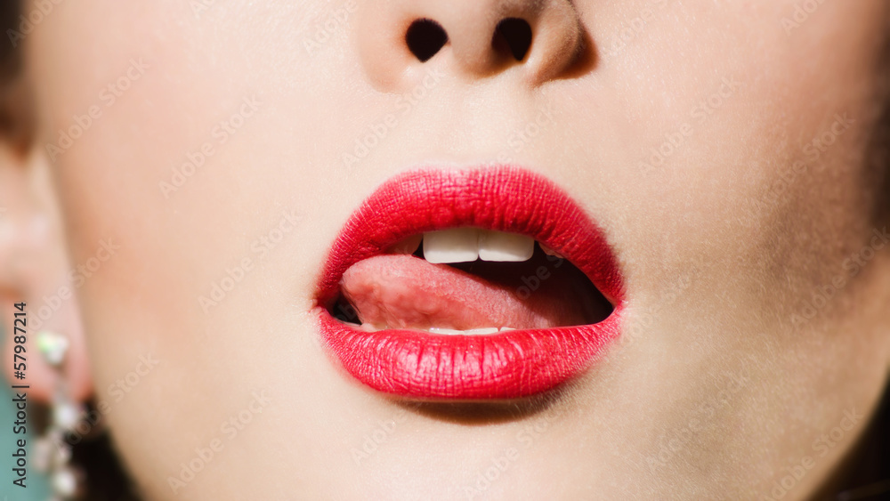 Fototapeta premium tip of tongue licks lips