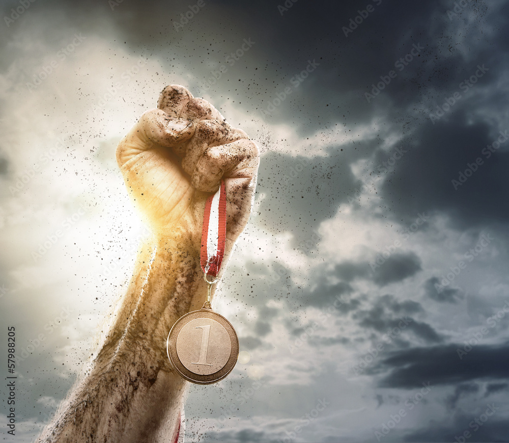 Success, male hand holding gold medal against the dramatic sky - obrazy, fototapety, plakaty 