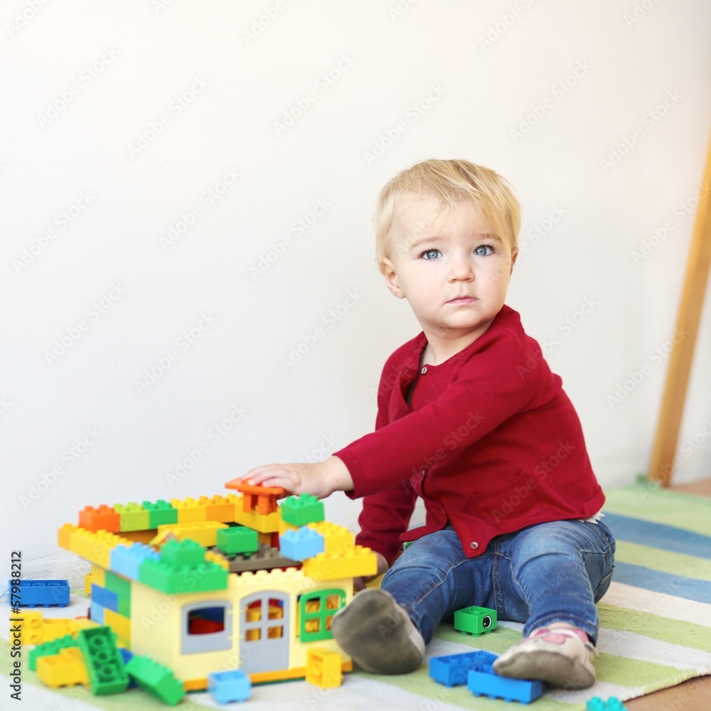 Cute toddler girl playing with plastic blocks indoors Cute toddler girl playing with plastic blocks indoors