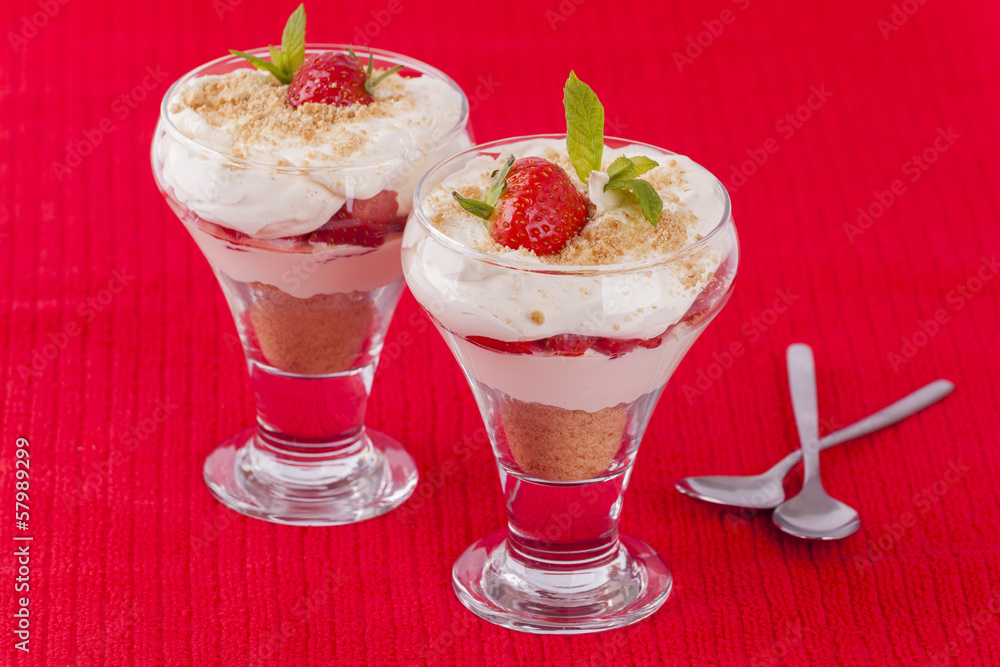 Two strawberry and cream desserts on red background Two strawberry and cream desserts on red background