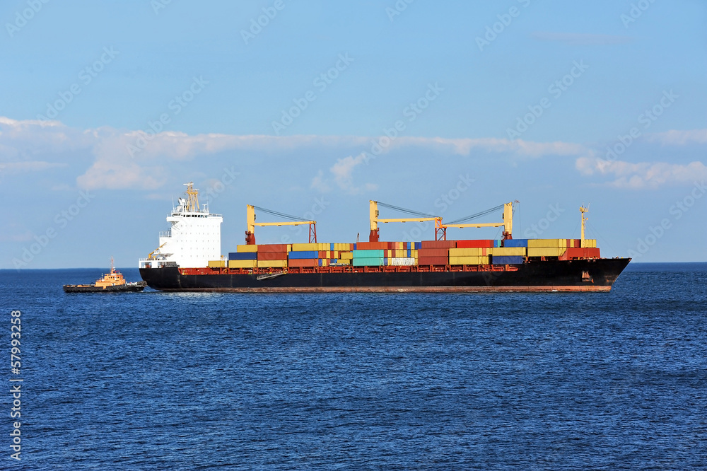 Tugboat assisting container cargo ship to harbor quayside Tugboat assisting container cargo ship to harbor quayside